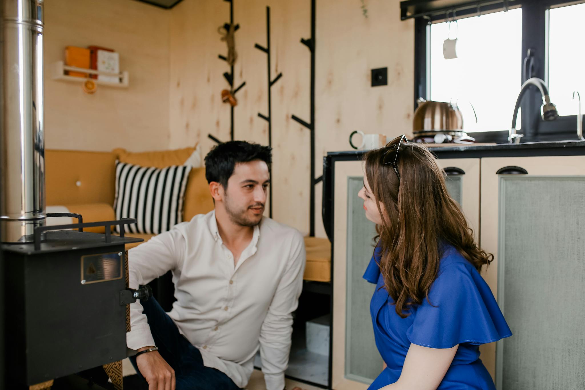 A couple enjoying a relaxed moment indoors in a modern cabin with stylish decor.