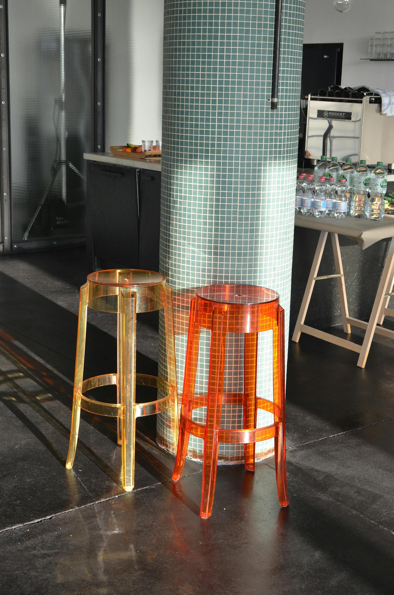 Chairs placed near pillar in light modern studio with various products on kitchen counter and special equipment for photo shoot